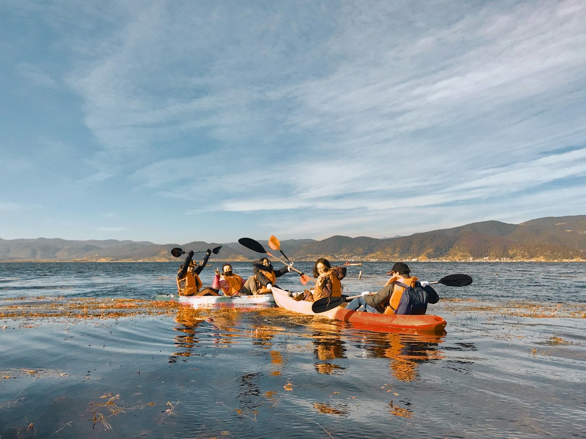 A group of friends kayaking together on open water